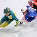 Three men in full-body lyrca suits race are racing on ice.