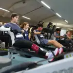 A photo of four athletes with a disability in action on rowing ergs.