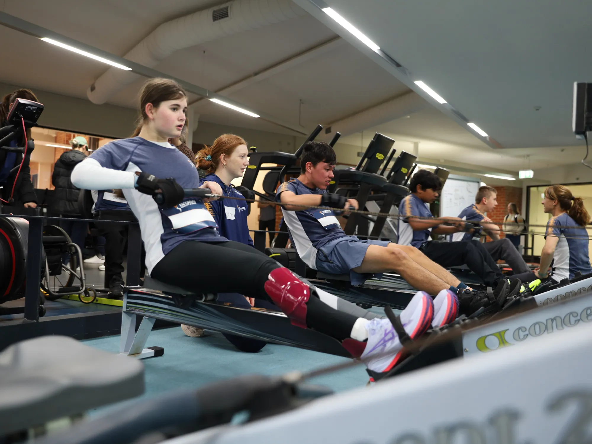 A photo of four athletes with a disability in action on rowing ergs.