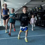 Children running down the track inside the VIS gym