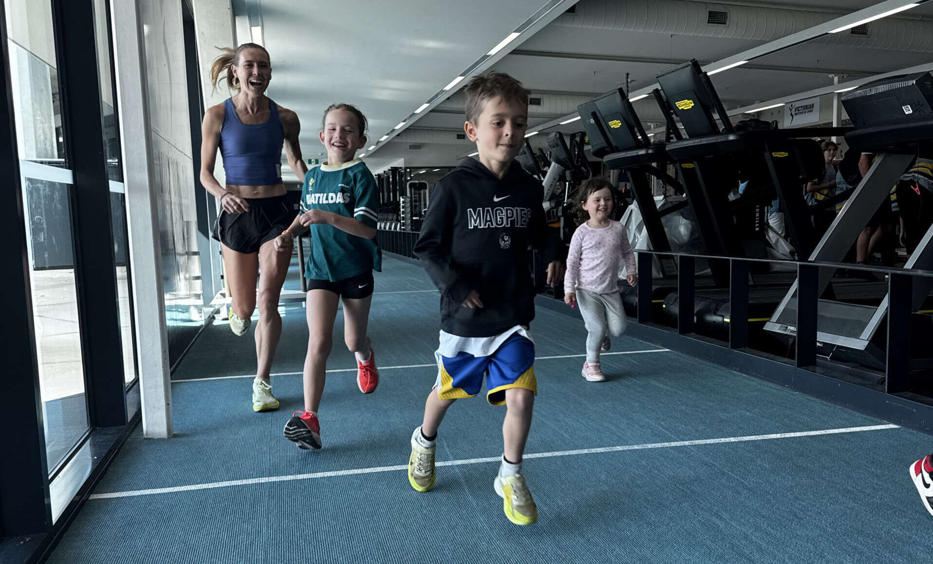 Children running down the track inside the VIS gym