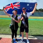 James Willett and Catherine Skinner celebrating by holding up Australian Flag and smiling at the ISSF Shotgun World Cip 2026.